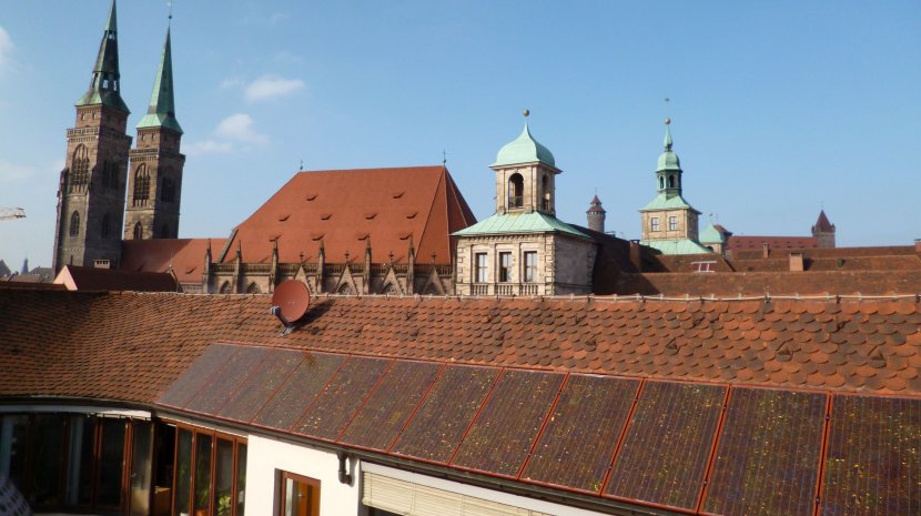 PV-Anlage mit roten Modulen auf dem denkmalgeschützten Rathaus am Hauptmarkt PV-Anlage mit roten Modulen auf dem denkmalgeschützten Rathaus am Hauptmarkt
